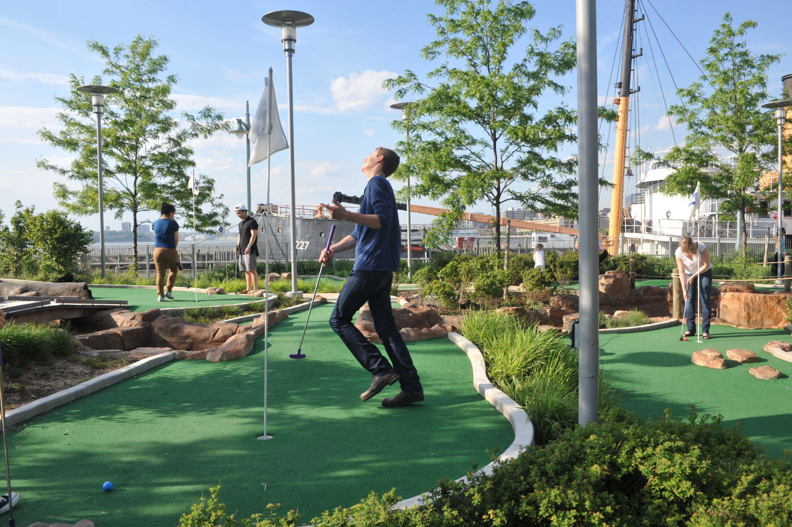 A mini golfer celebrates putting the ball into the hole at Hudson River Park's Pier 25