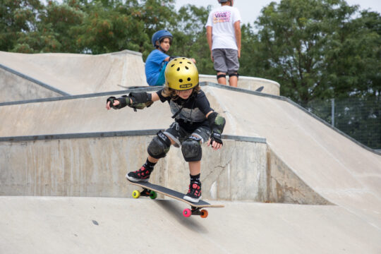 A skateboarder in a gold helmet skates down the hill at Pier 62