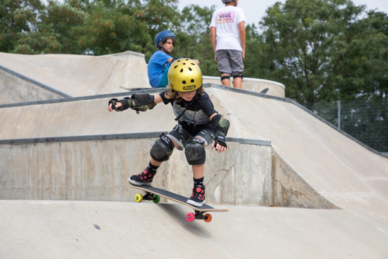 A skateboarder in a gold helmet skates down the hill at Pier 62