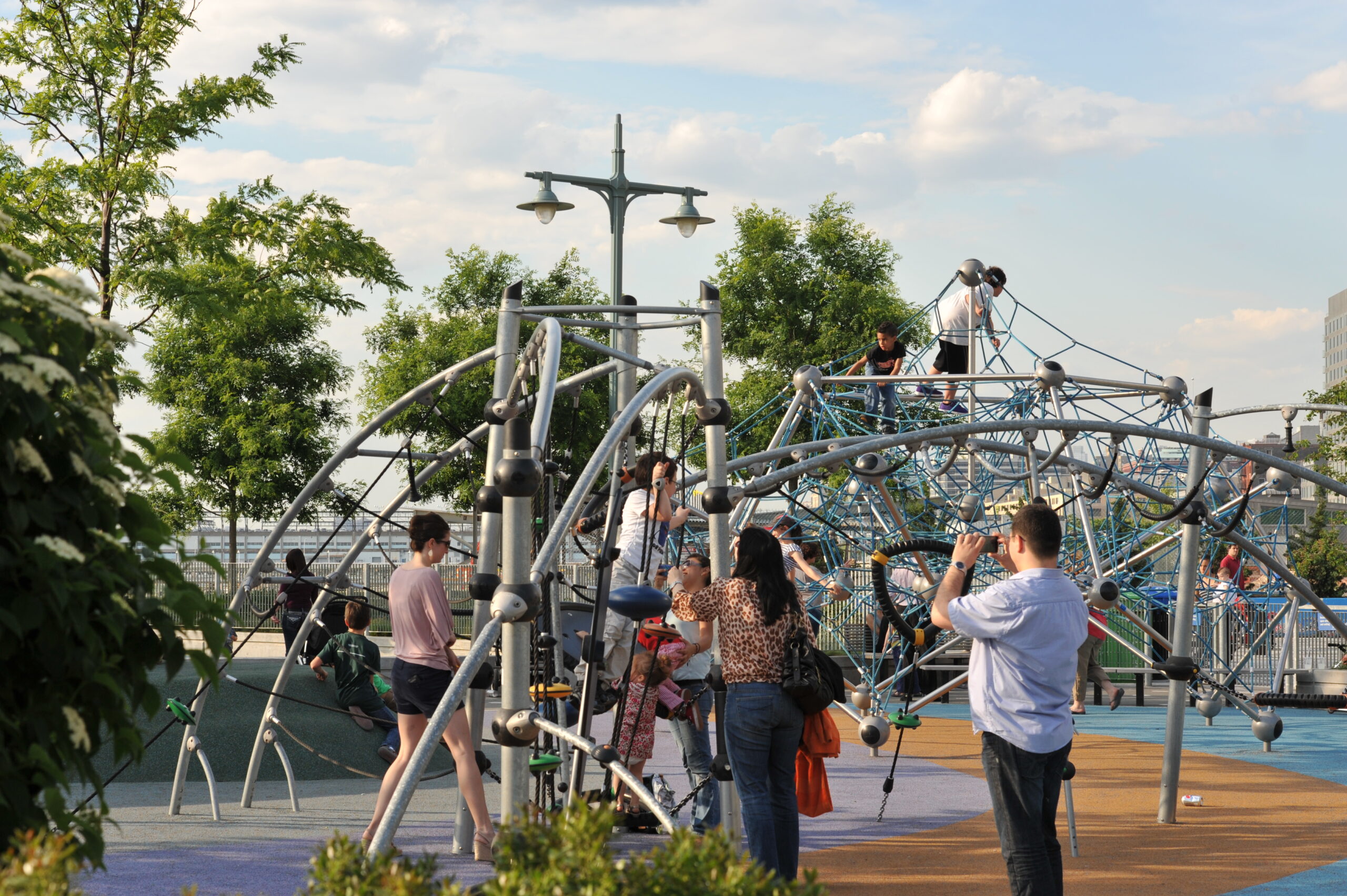 Children and their parents play on the jungle gym at Hudson River Park's Pier 25