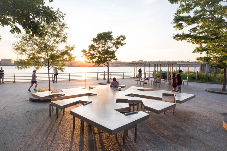 Sunset at the art piece Two Too Small Tables, a metal piece of a table structure and chairs attached to sit