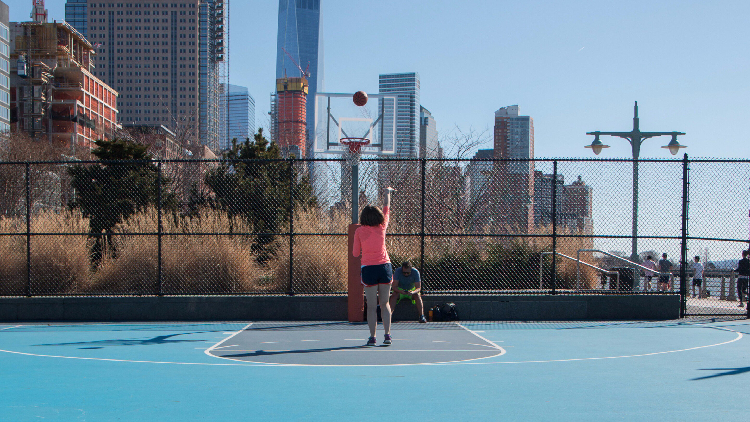 A basketball player shoots a basket on the Canal Street Basketball Courts