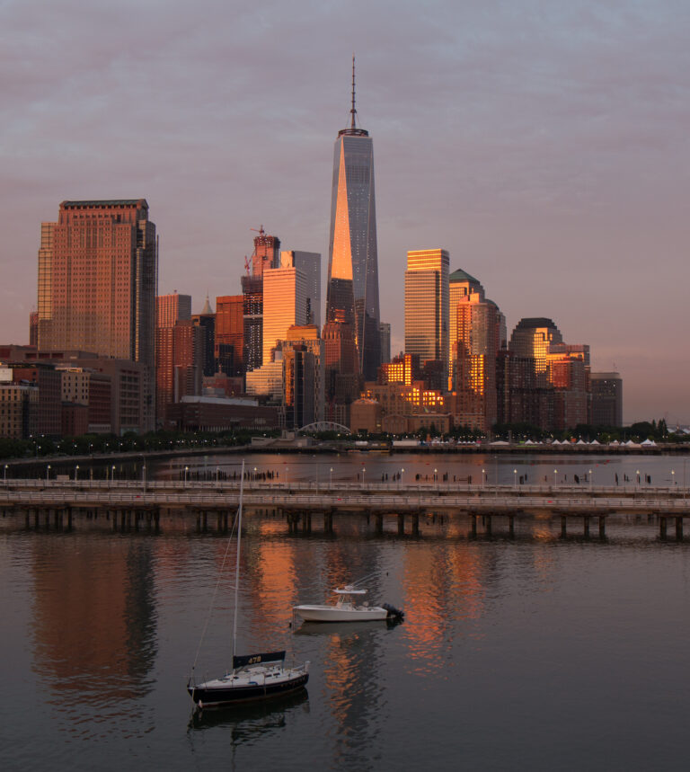Boats in the mooring field at Pier 40 at sunset, with the Lower Manhattan skyline in the distance