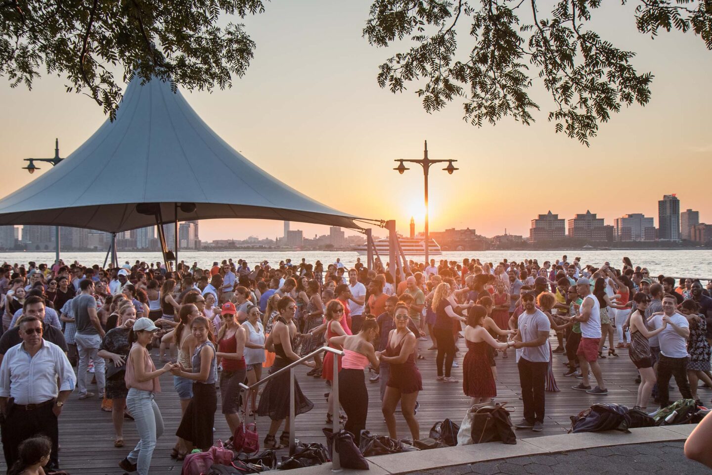 The sun beings to set and under the canapé at Pier 45, Park visitors learn how to salsa dance