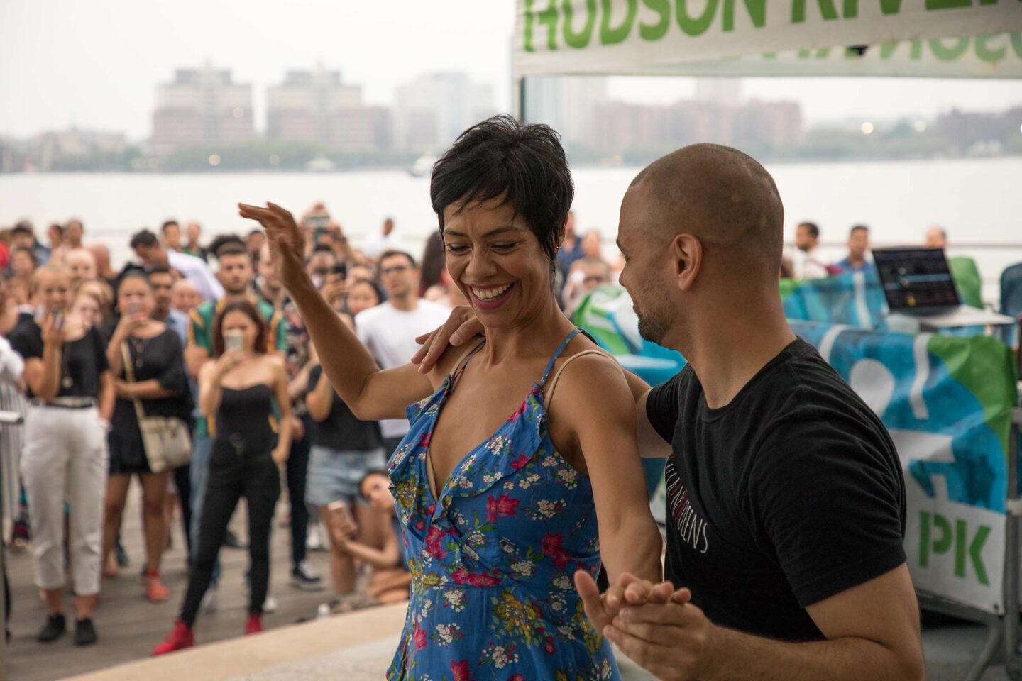 Talia smiles and prepares to turn during a salsa dance demonstration