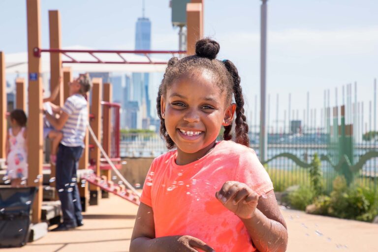 A young girl enjoying bubbles at Pier 51's playground