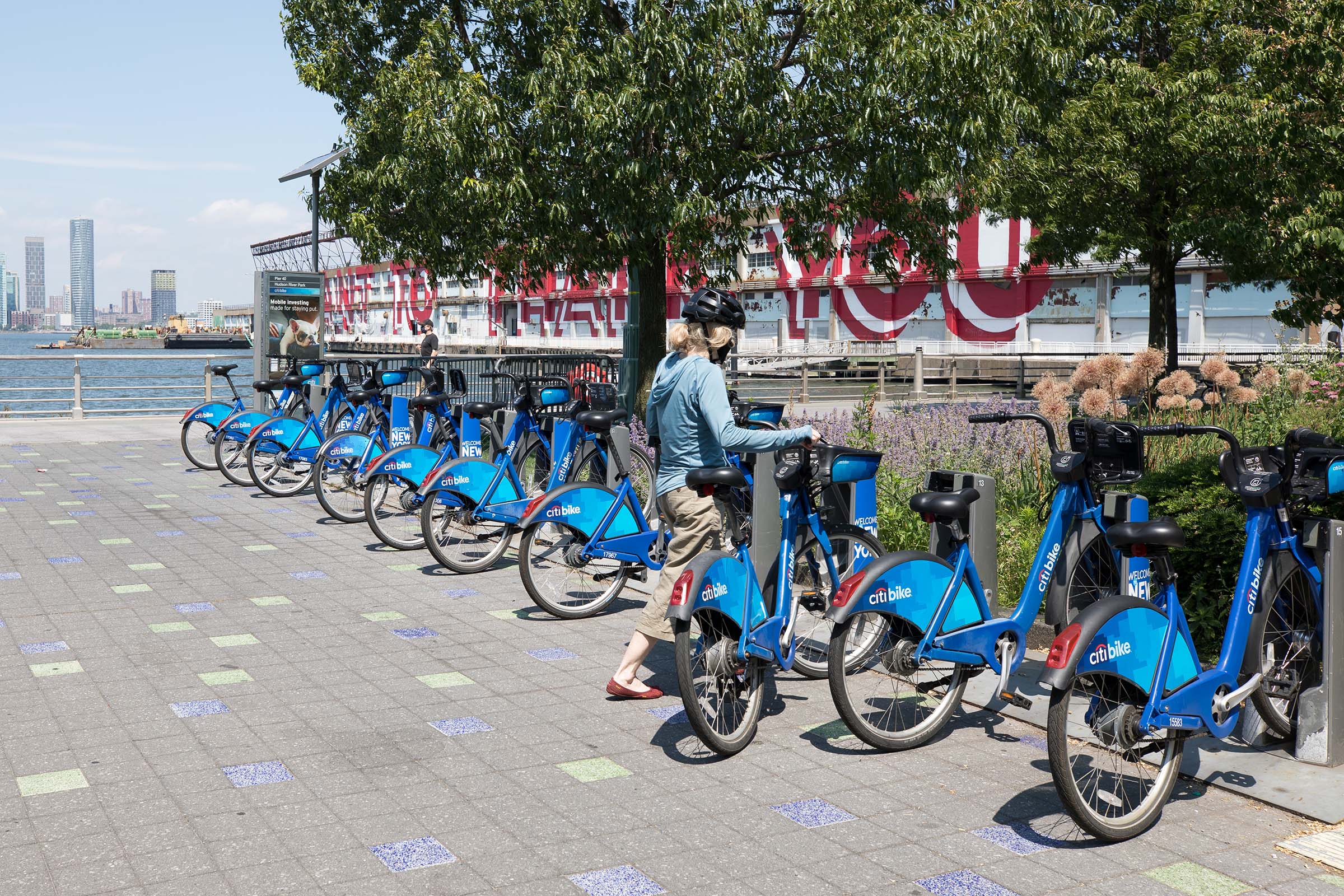 A biker locks her bike into the citi bike kiosk