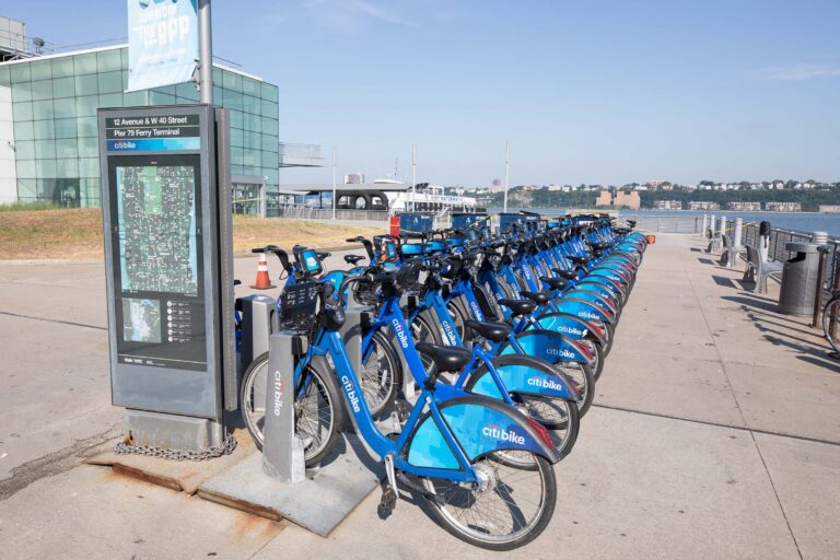 The citi bike kiosk filled with blue and white bikes