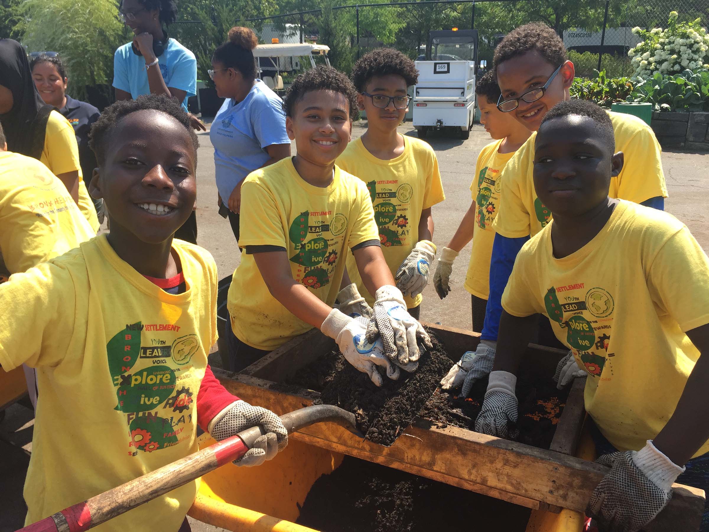 Learning about the soil, a group of kids in yellow shirts smile at the camera