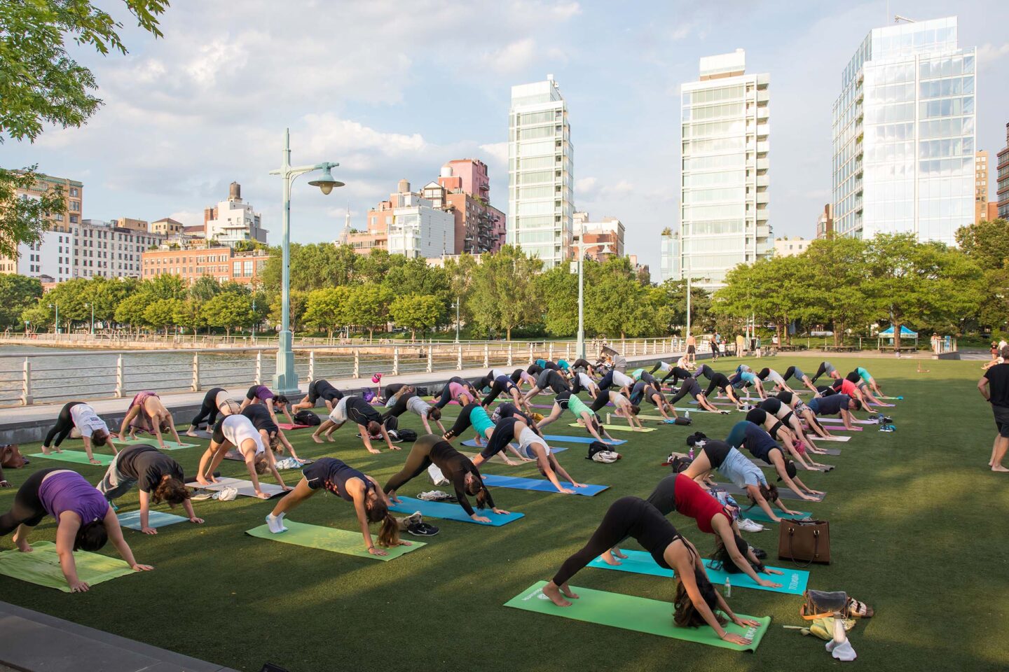 Yoga enthusiasts practice yoga with a downward dog move at Pier 46