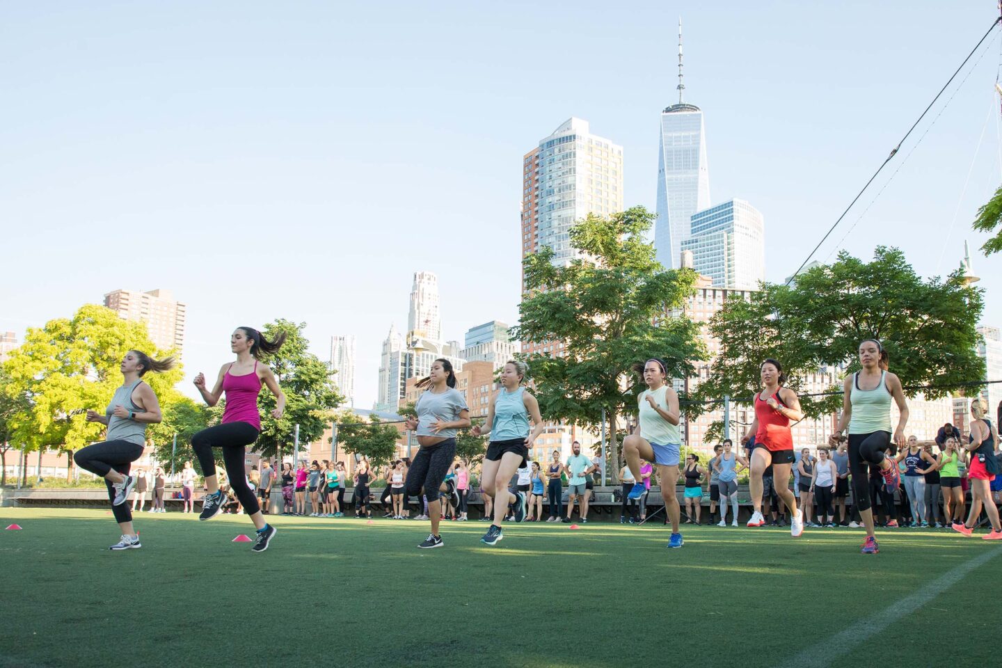 Participants at an exercise class jog down the field getting their heart rates up