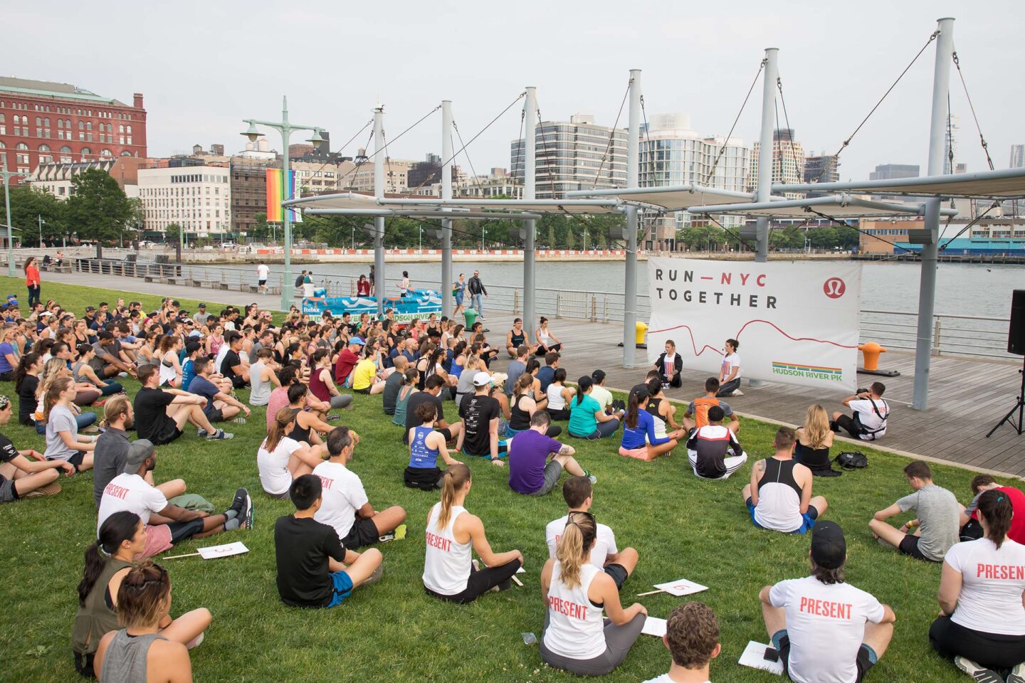 A group of participants for Run-NYC Together sit and stretch and discuss the upcoming race