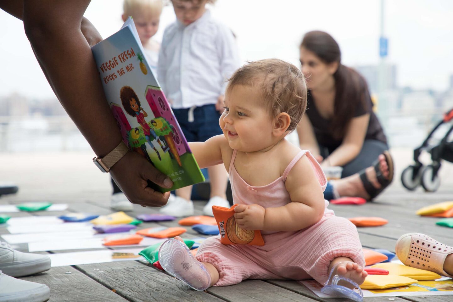 A baby smiles at the pictures in the book