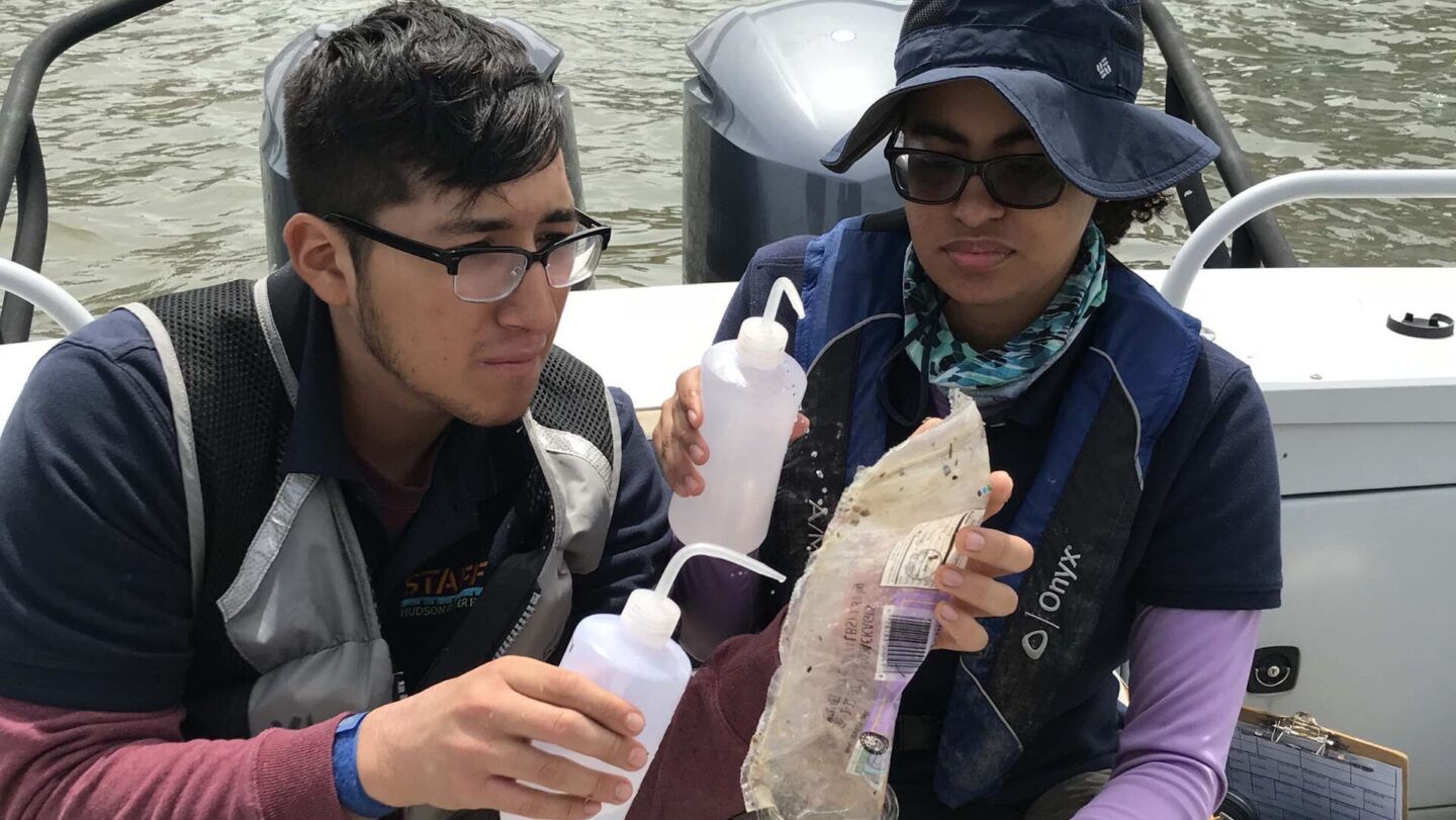 Scientists look at the microplastics on a boat in the river