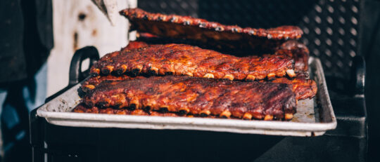 BBQ Ribs sit on the grill awaiting eager fans to eat