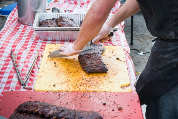 A server of the bbq ribs take great care in slicing the meat at Blues BBQ in Hudson River Park