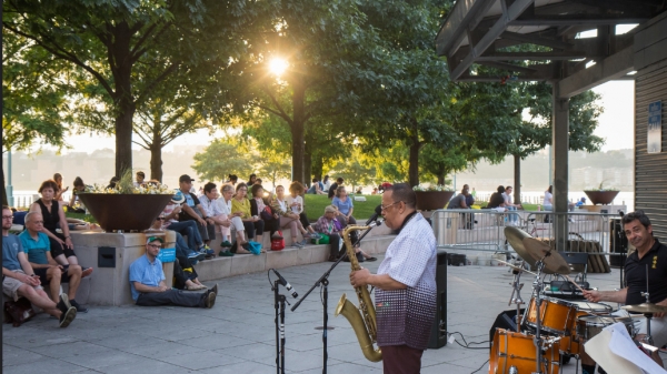 Park visitors sit and enjoy the sunset as Jazz at Pier 84 begins