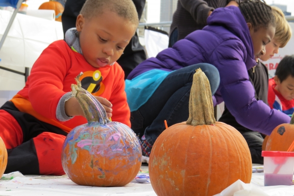 Kids in costumes paint the pumpkins during Pumpkin Smash