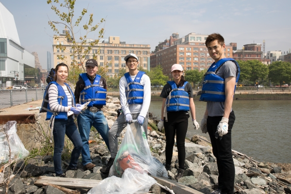 A group of volunteers help pick up the plastic trash that finds its way into the river