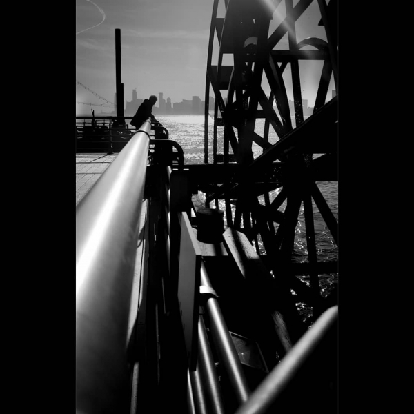 A black and white image of the art pier Long Time, the water wheel on Pier 66, sent in by Park visitor @blensaw