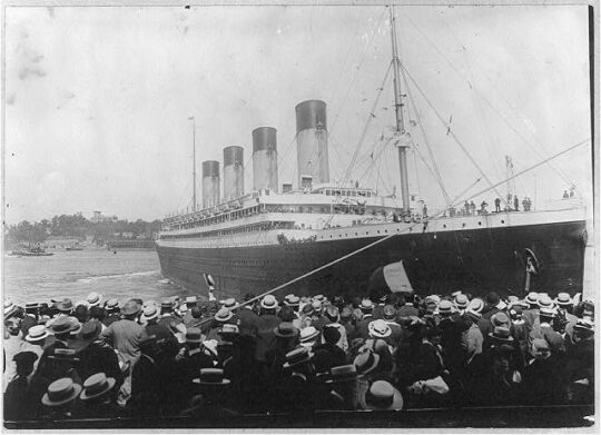 The Olympic, a majestic cruise vessel sits in New York Harbor with a crowd welcoming it