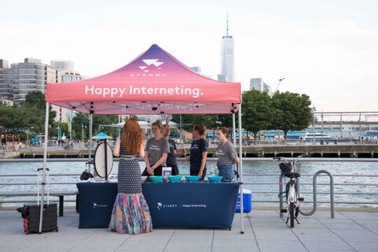 A tent with representatives from Starry internet service speak with Park visitors at Pier 45