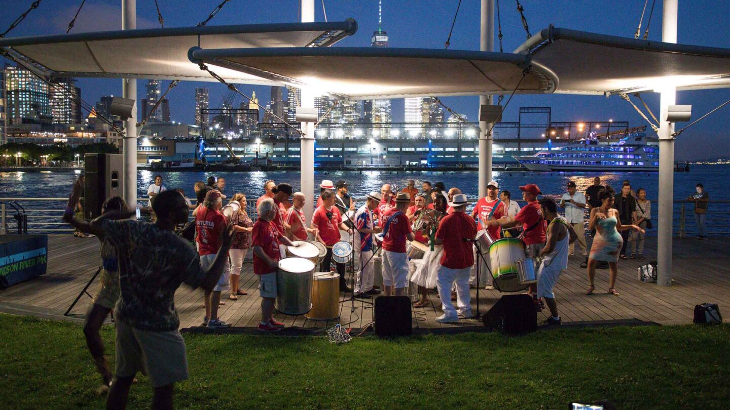 The group of musicians in Manhattan Samba play their percussion instruments