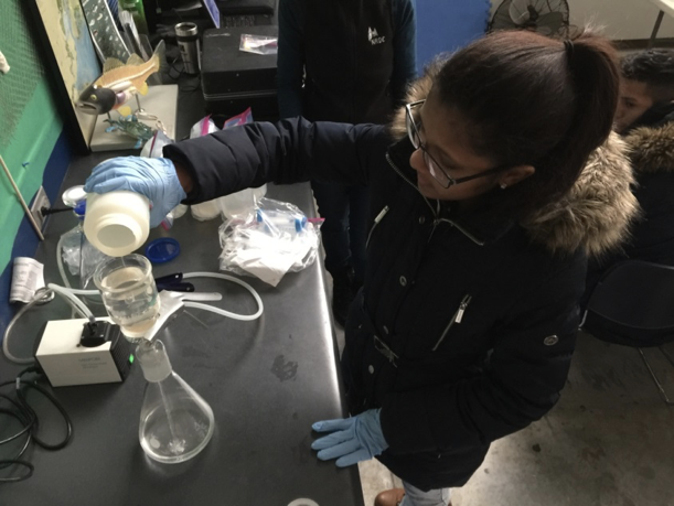 Pouring solution into a water sample in the lab
