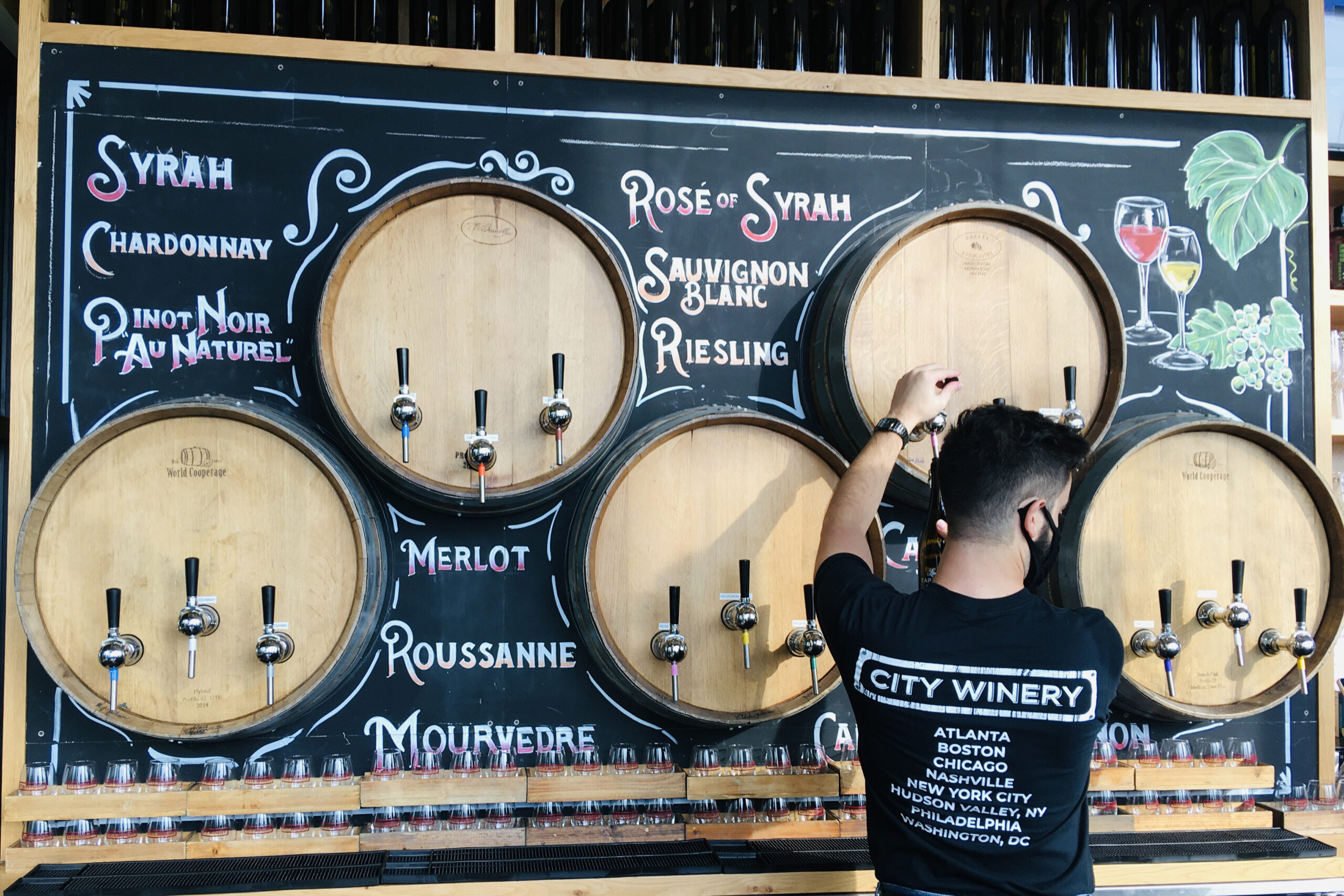 A City Winery staffer pours a glass of wine from a tap in a barrel embedded in the wall
