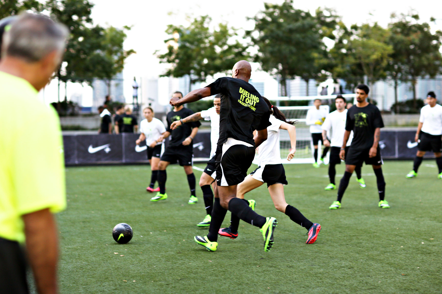 Soccer players running toward the ball during a Nike Fuel event on Pier 25's turf field