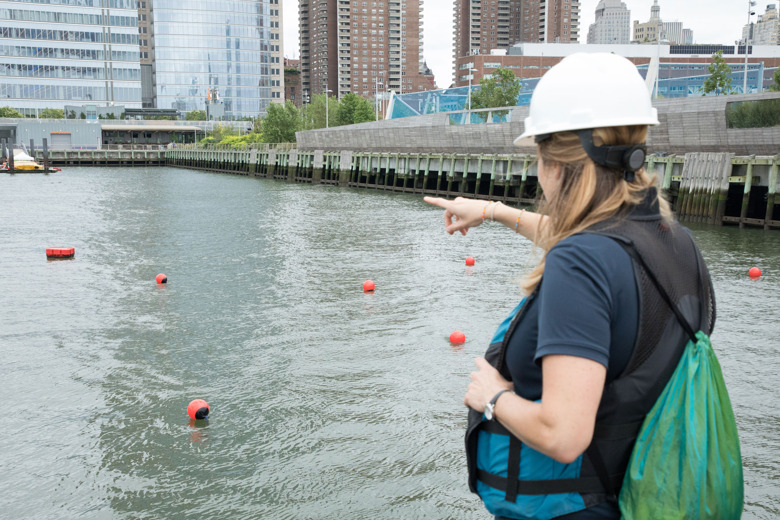 HRPK River Project educator points out at the water as she leads the oyster gabion installation in Hudson River Park Tribeca Habitat Enhancement Project