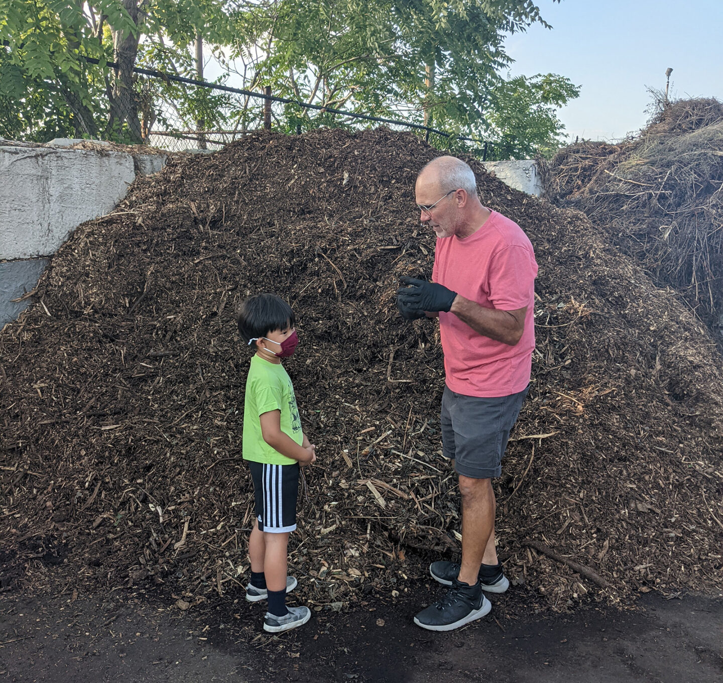 man and child in front of compost