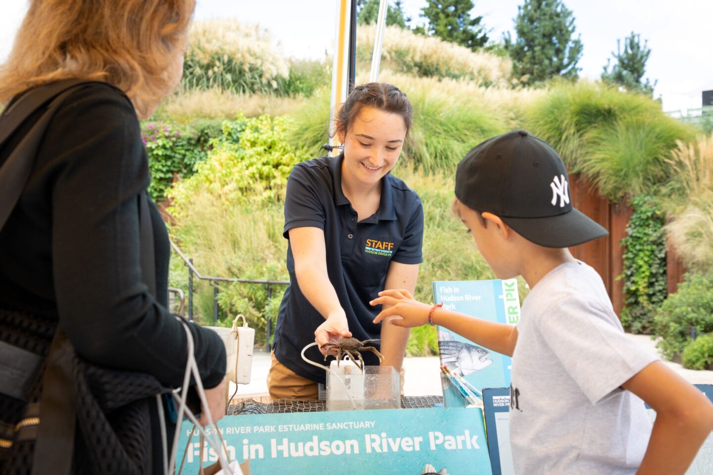 An HRPK Staff member showing a child and their parent a crab