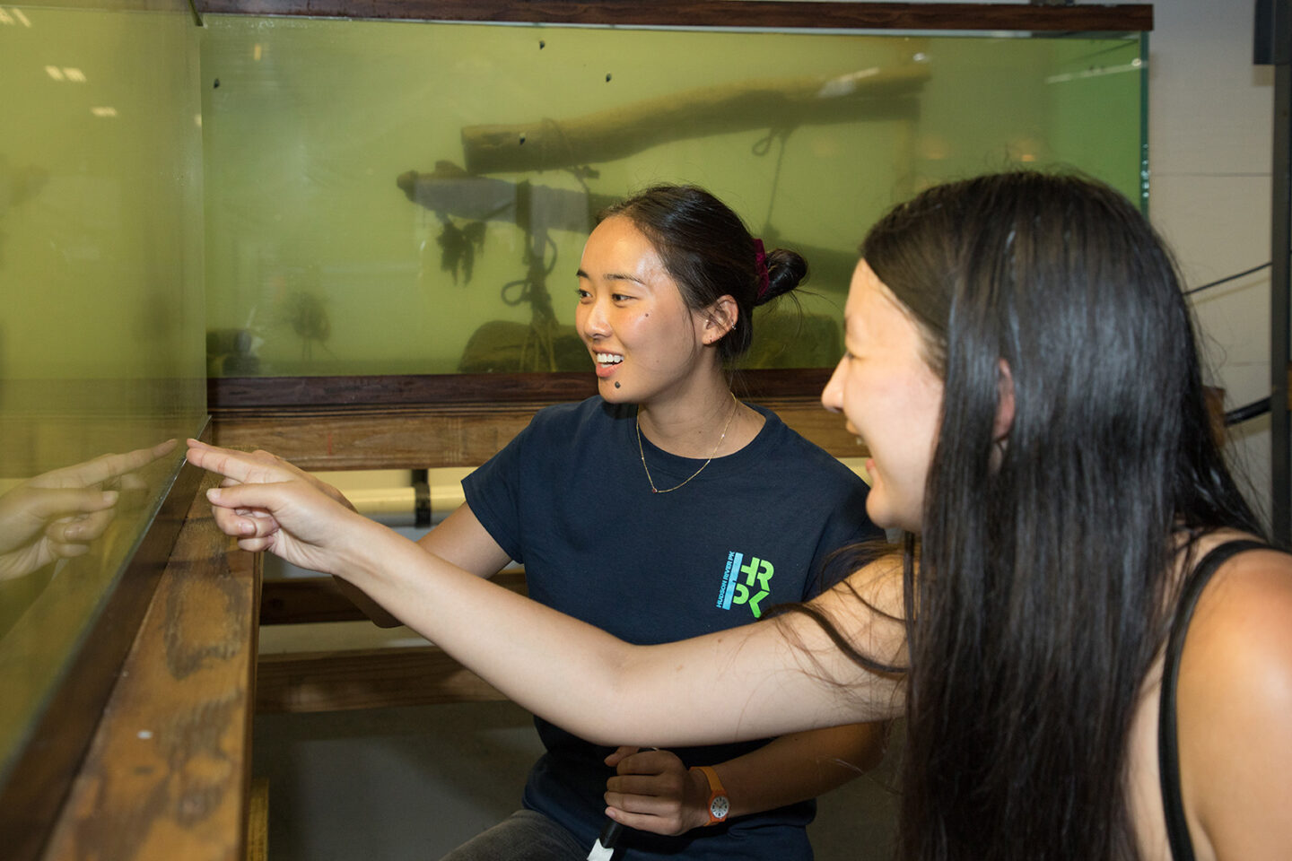 An HRPK River Project staffer leads a Wetlab visitor on a tour of an aquarium tank