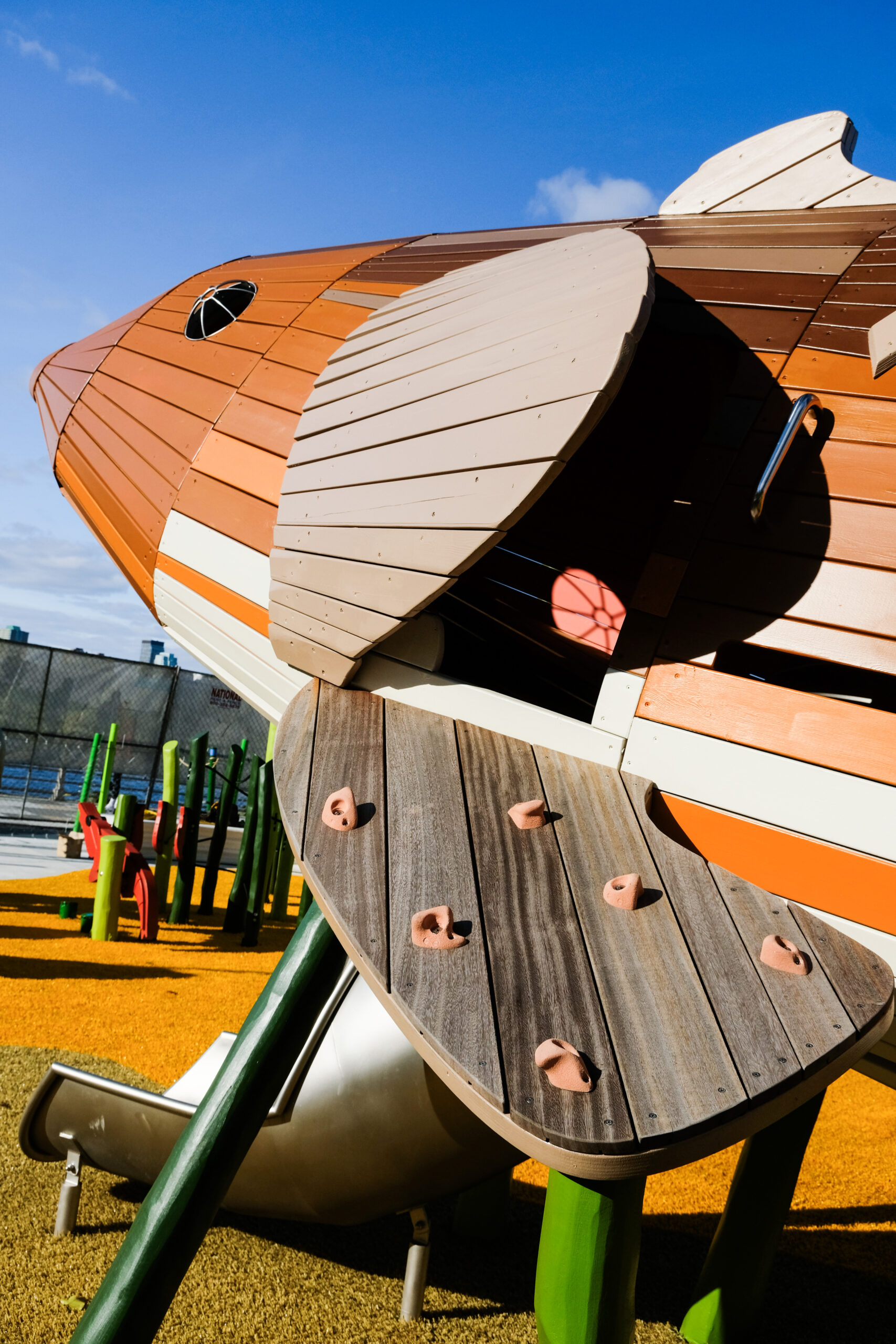 A playground structure shaped like a sturgeon has a series of climbing grips to bring playground visitors inside the sturgeon