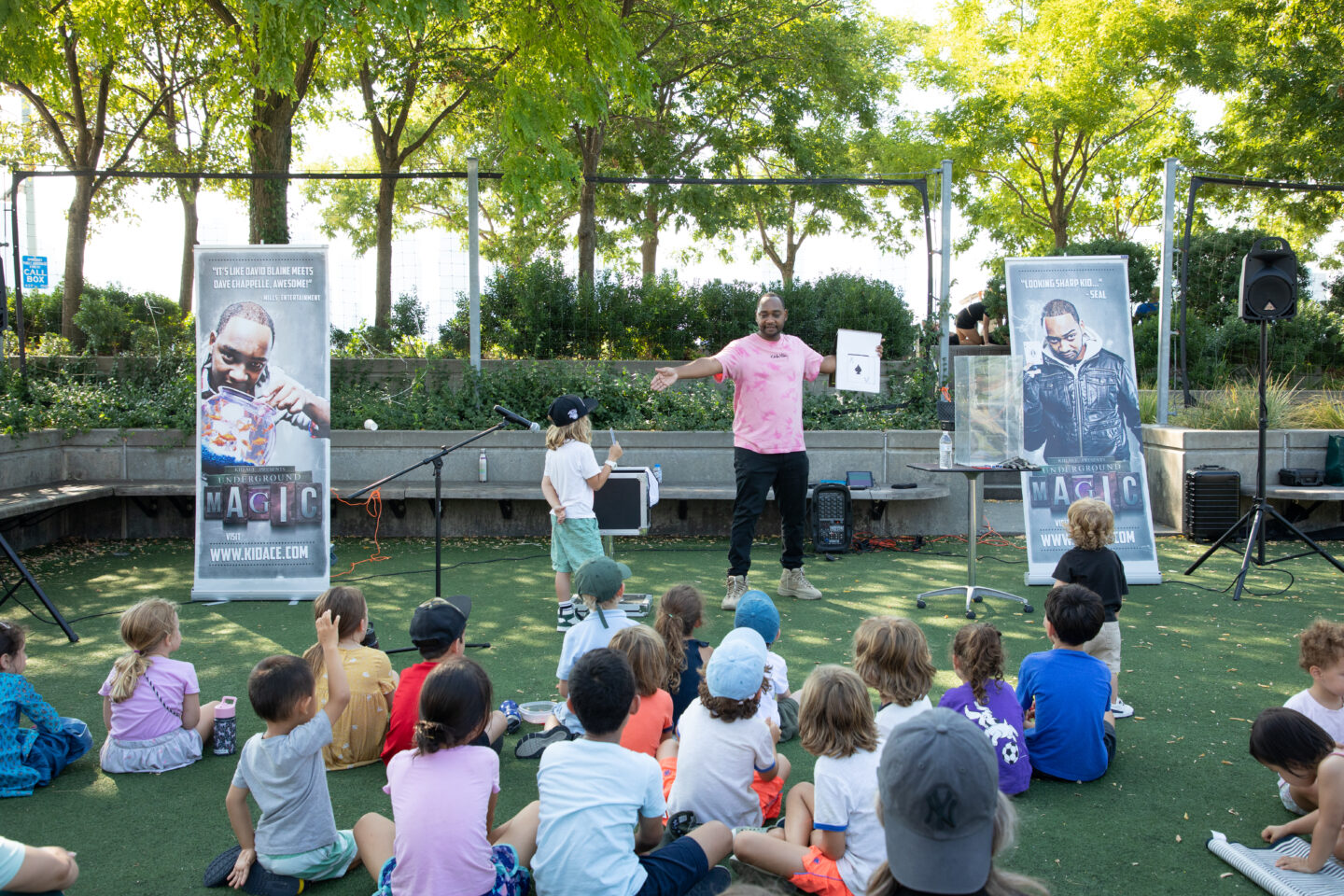 Magician Kid Ace performs at Pier 25 during Hudson RiverKids in front of kids on turf field
