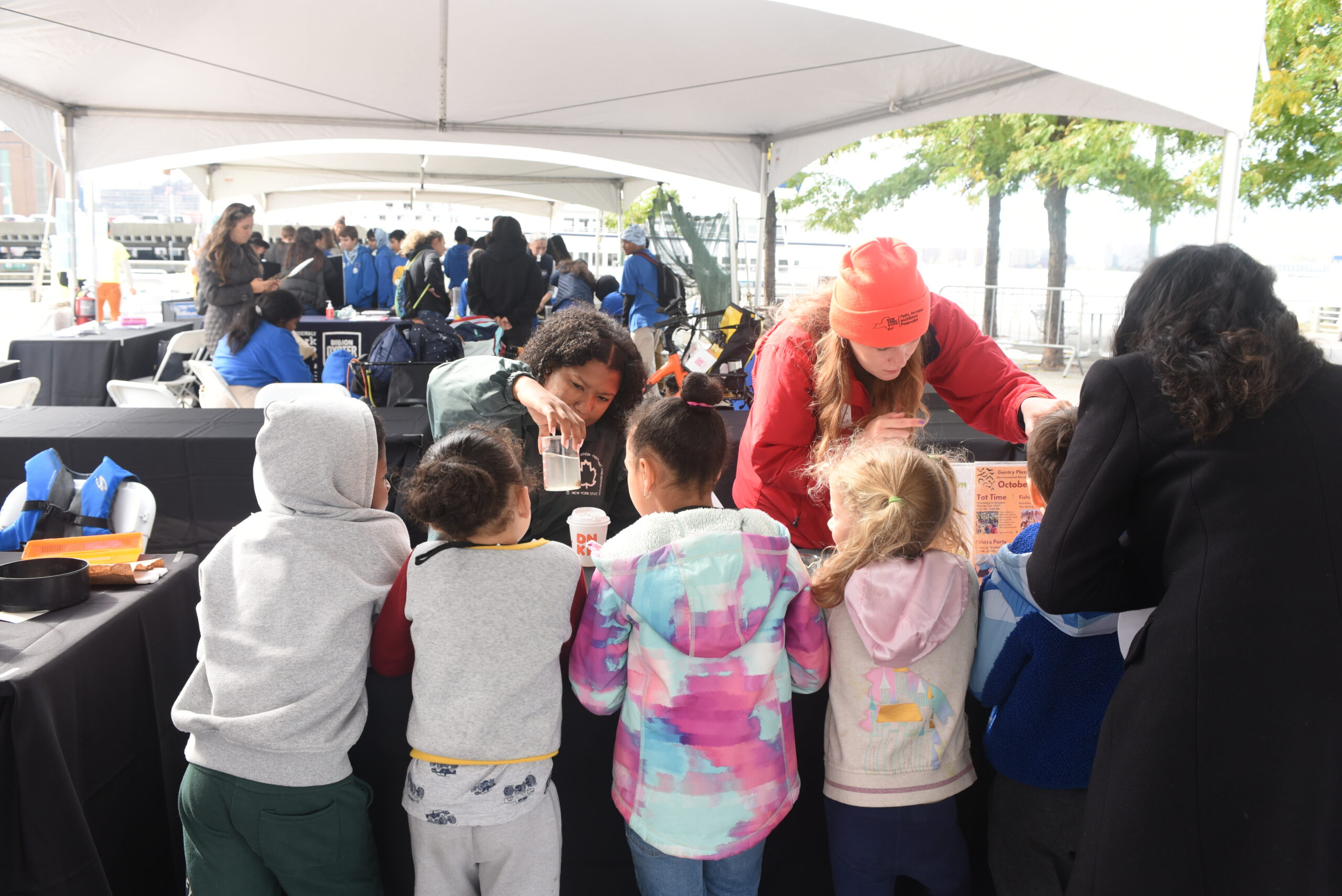 Four elementary students watching a presentation at a SUBMERGE Marine Science Festival table