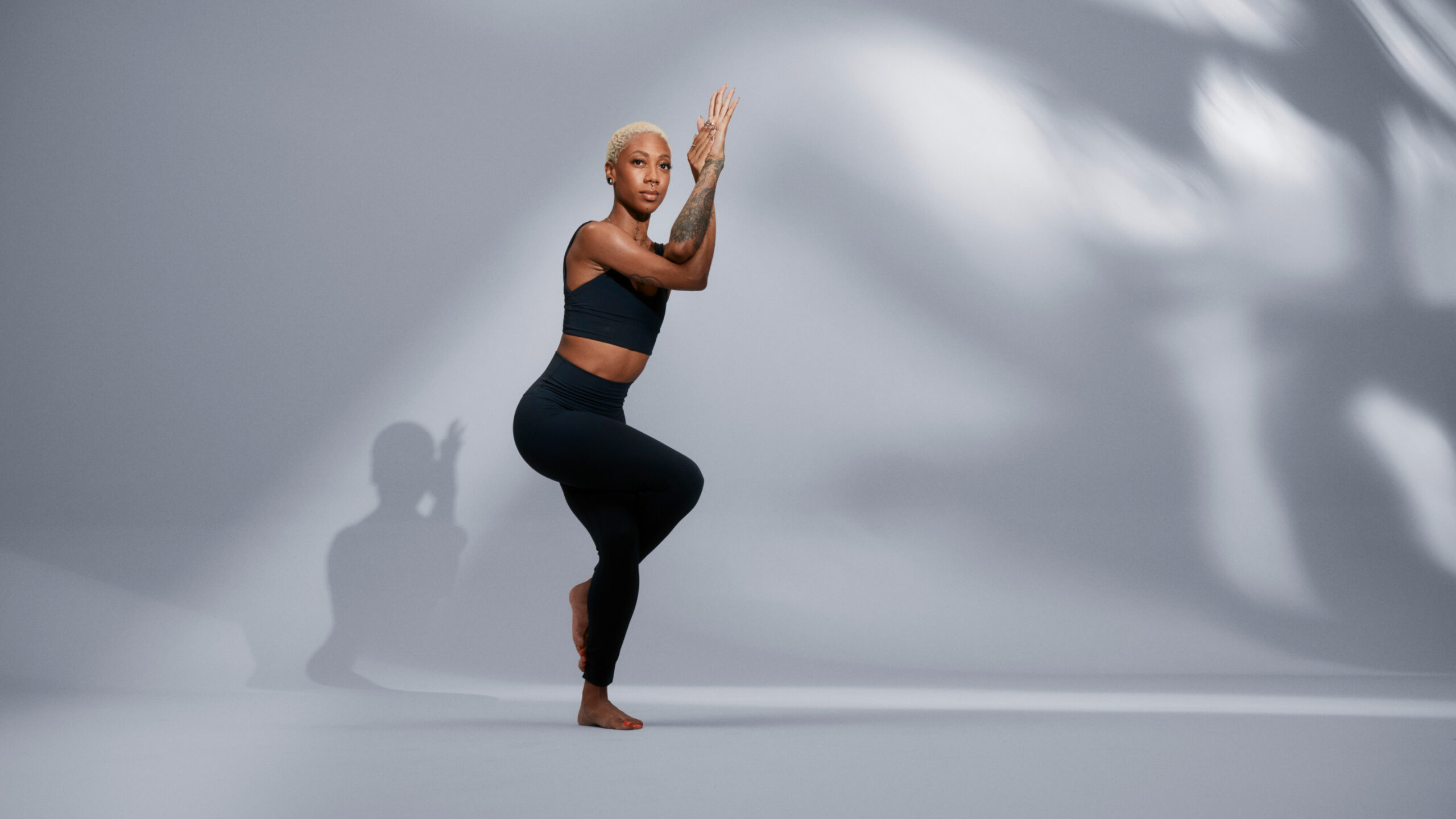 lululemon Studio Trainer poses in front of a grey background