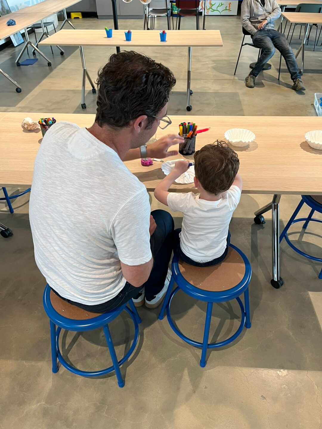 A parent and a child working on an an arts and crafts project at a table
