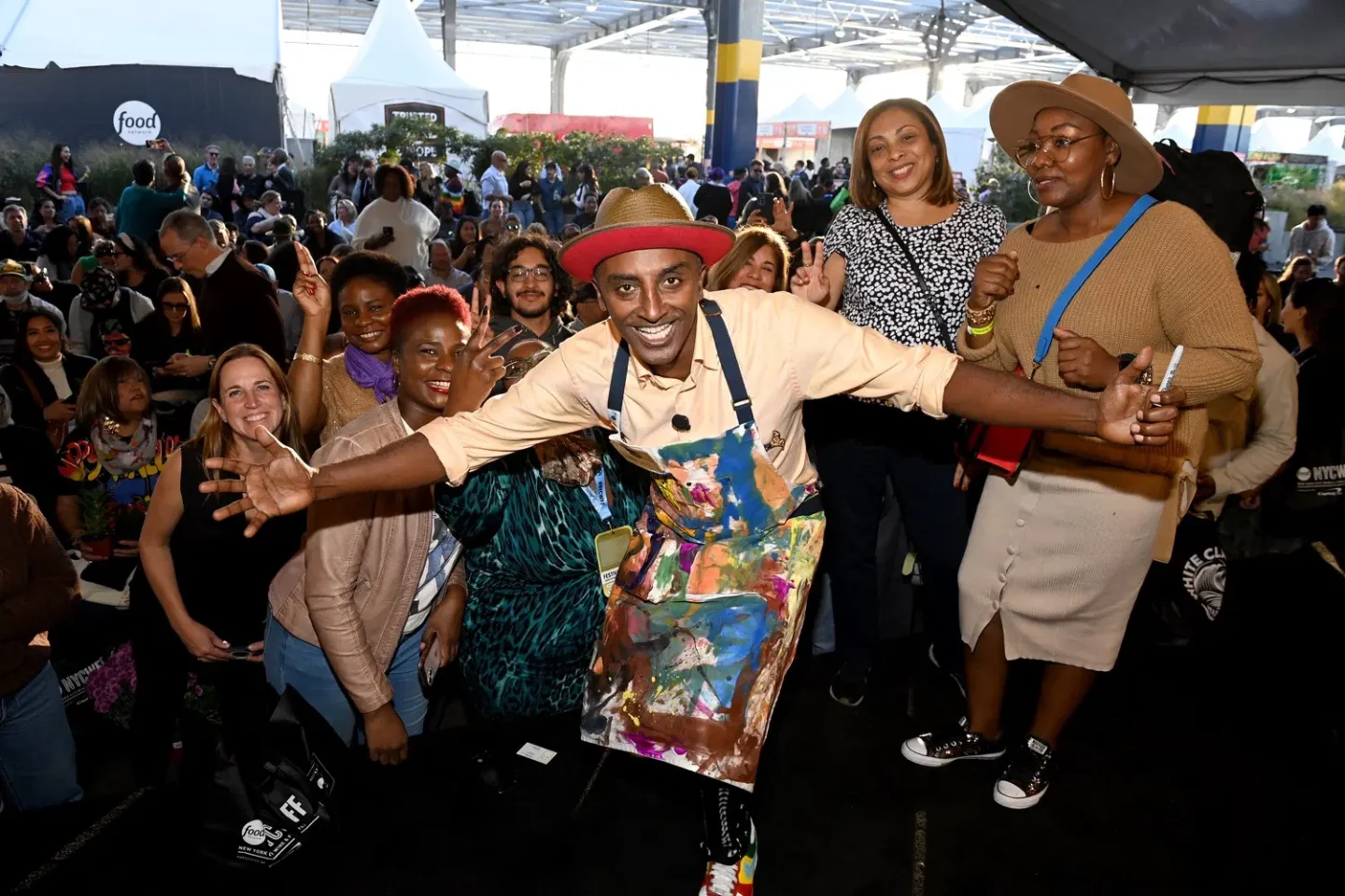 Chef Marcus Samuelsson standing with a group of fans at the New York City Wine & Food Festival