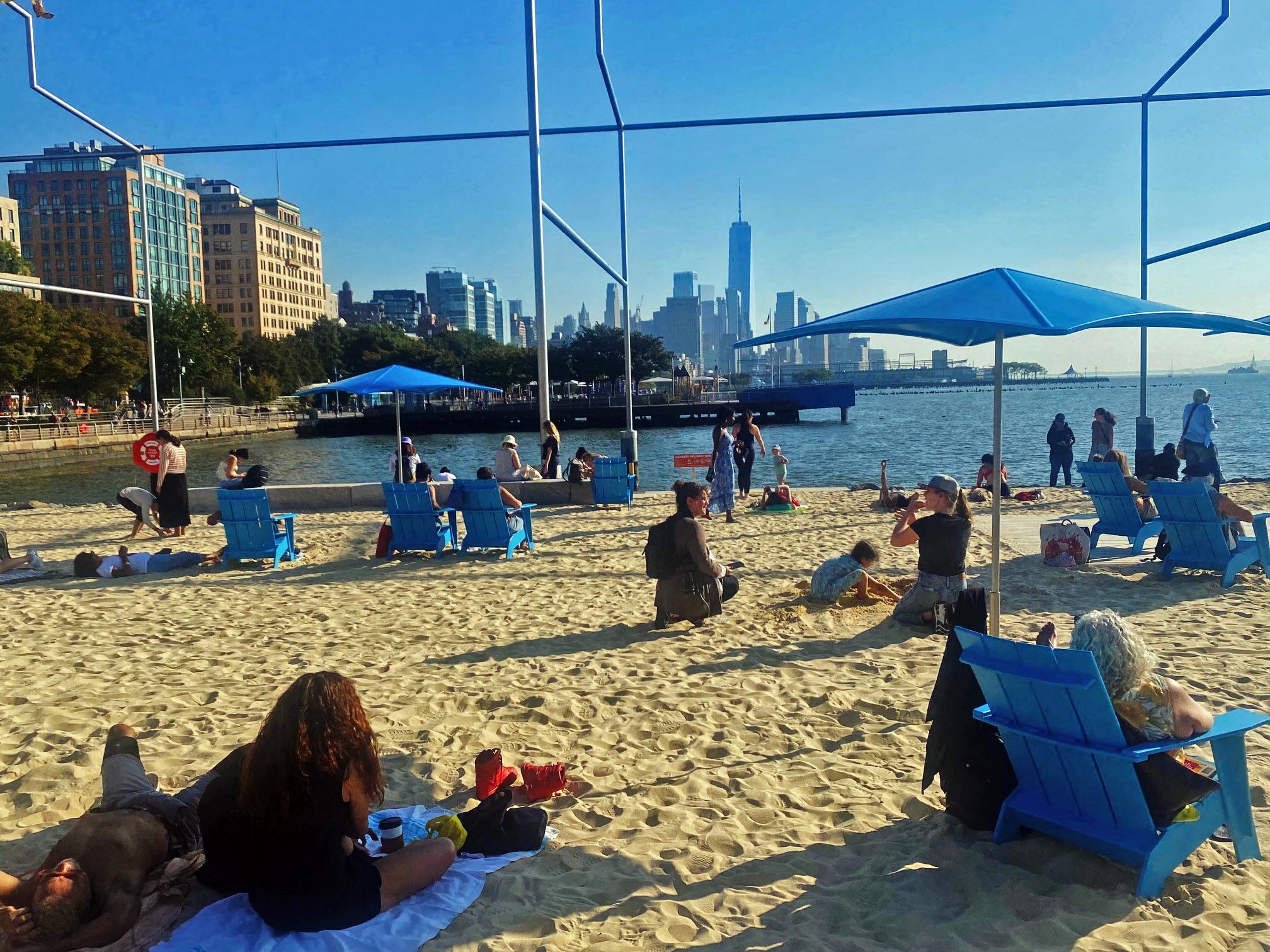 People sitting and lounging on the beach at Gansevoort Peninsula.