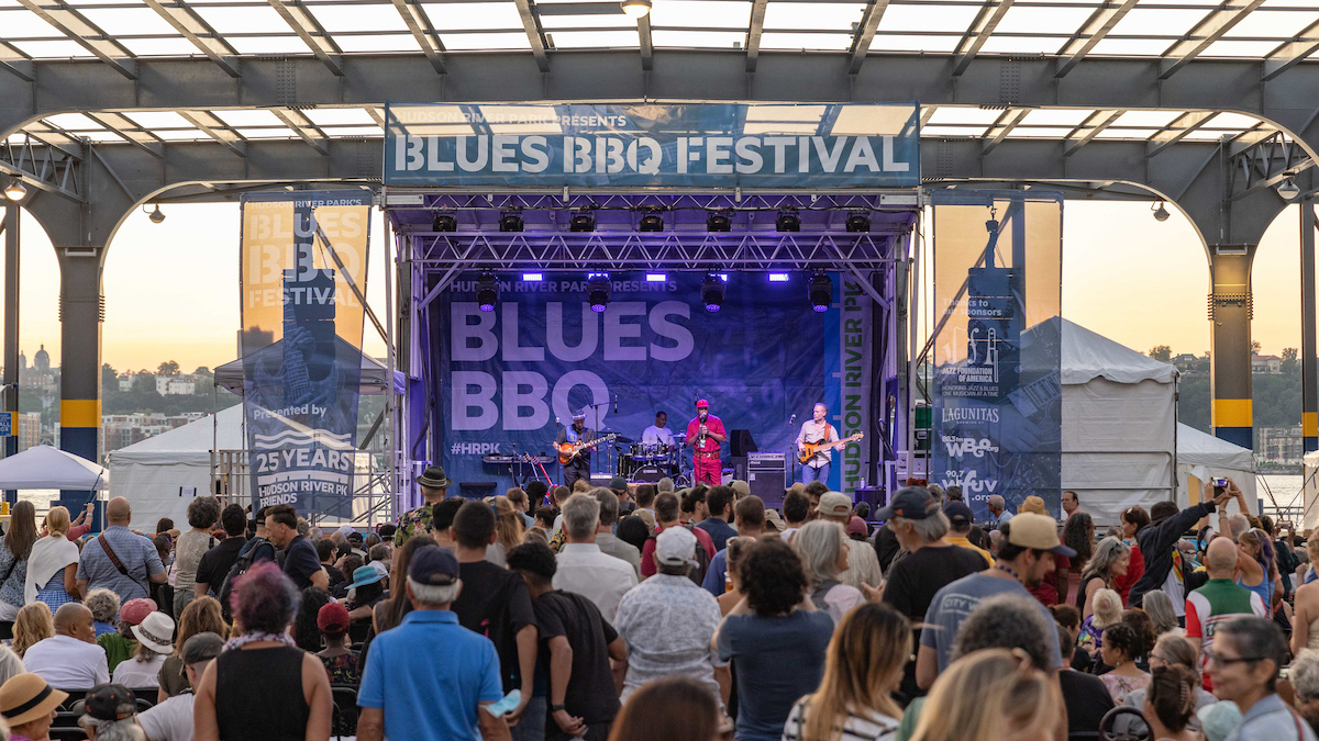 John Primer and the Real Deal Blues Band performing on stage in front of a large crowd at the Blues BBQ Festival on Pier 76