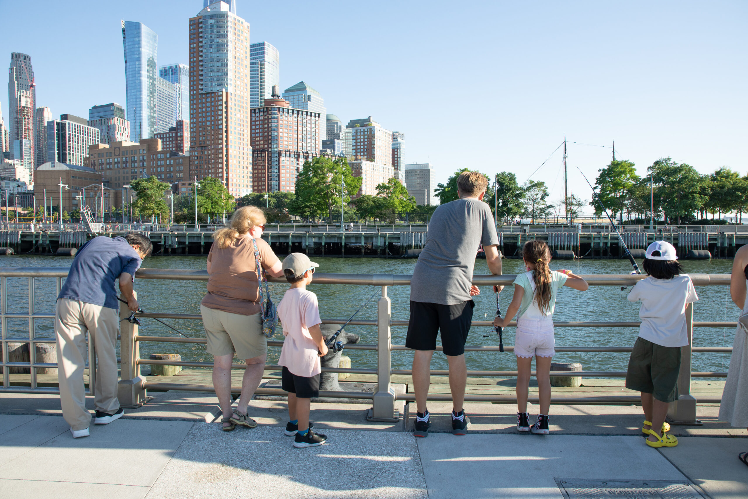 Children and adults cast lures at Big City Fishing on Pier 26