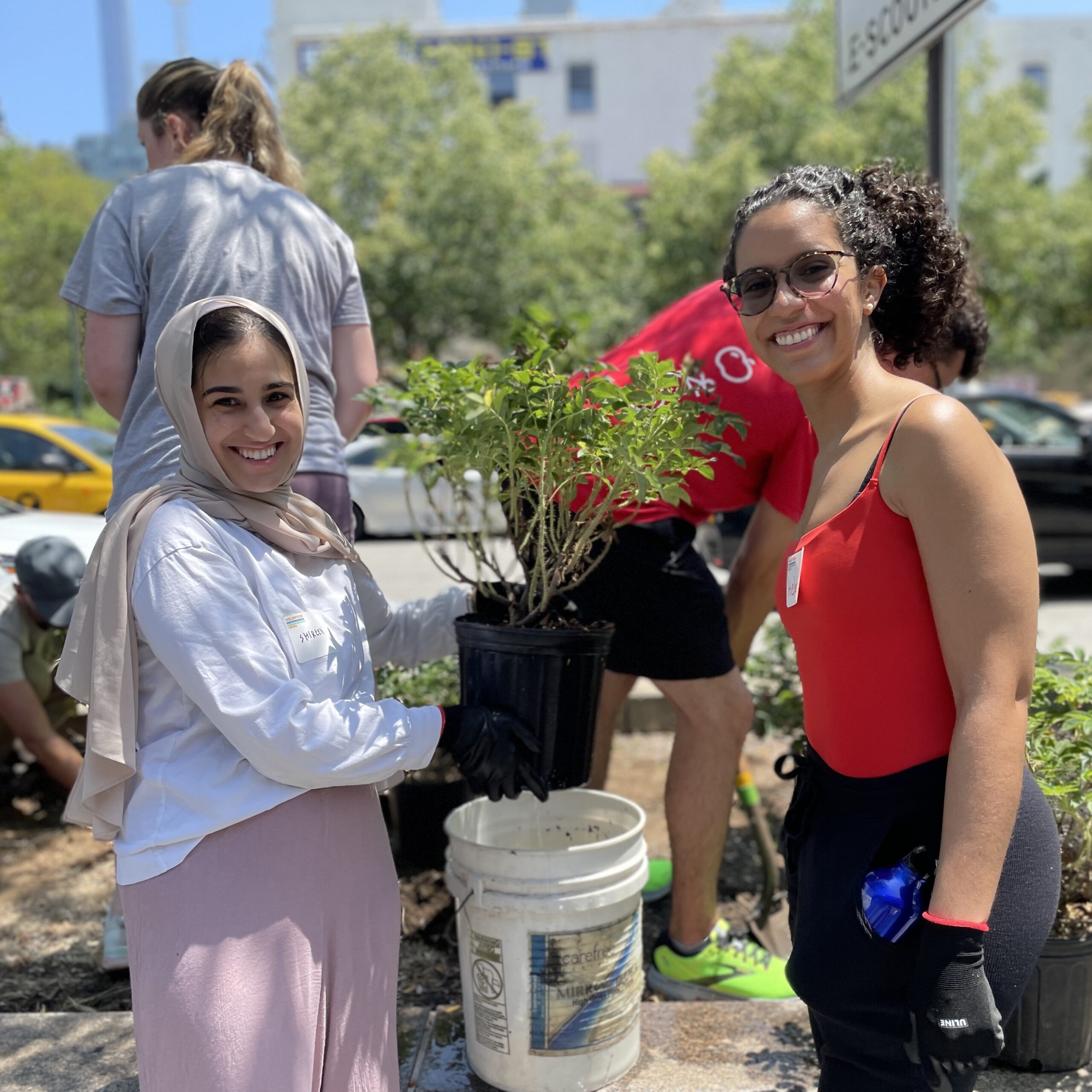 Two volunteers posing with a potted plant during a Park garden project