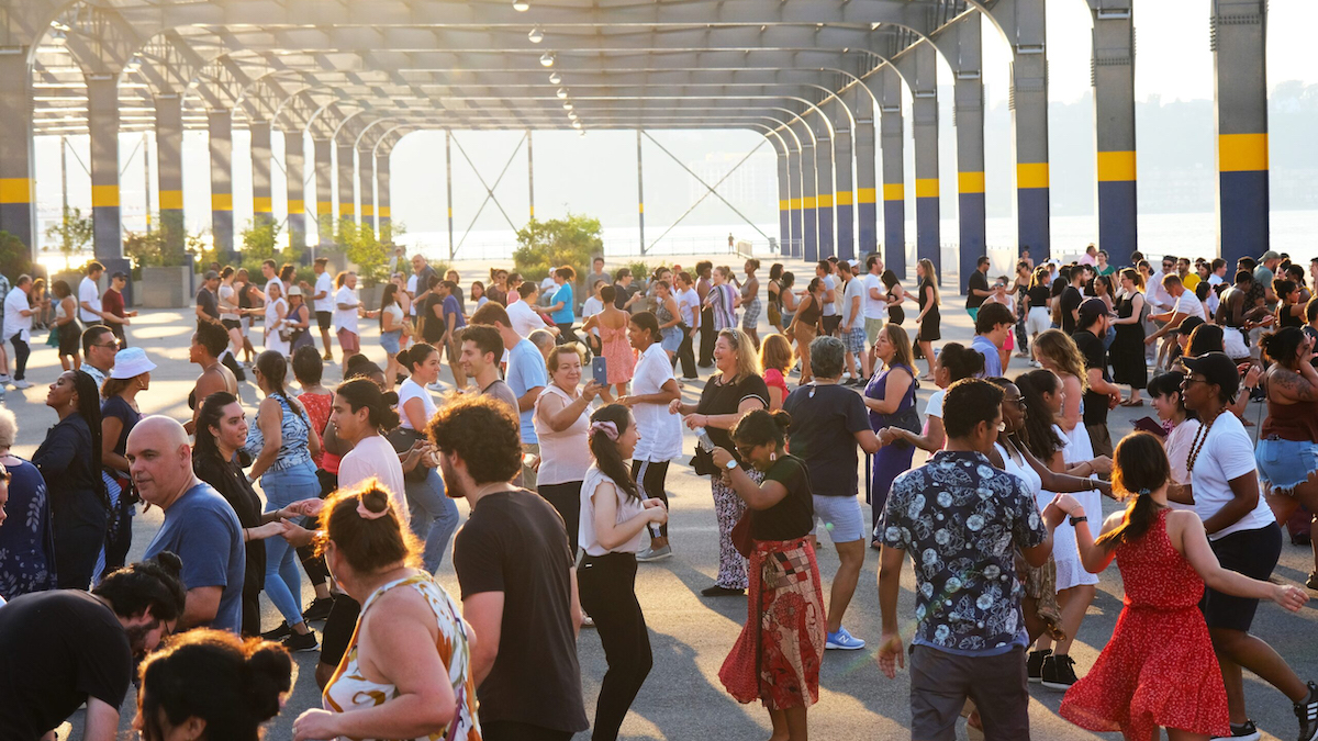 Park visitors dance in a group during a Sunset Salsa class on Pier 76