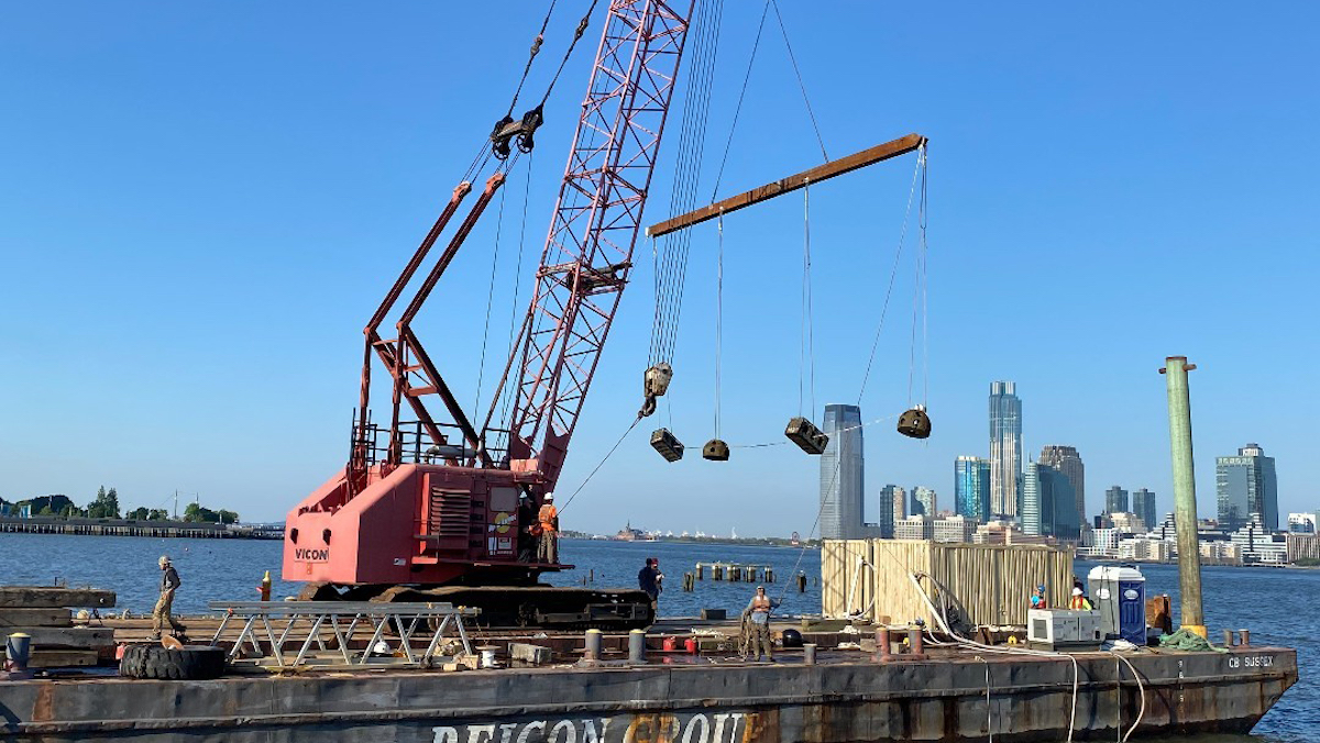 A construction crane moving materials around on a barge