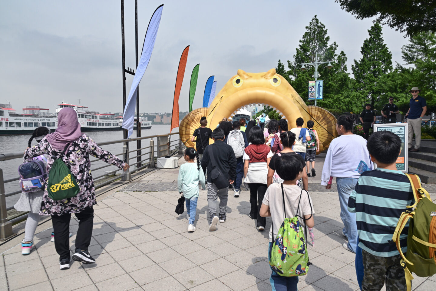 A group of students walk toward the inflatable oyster toadfish arch at the entrance to the SUBMERGE Marine Science Festival