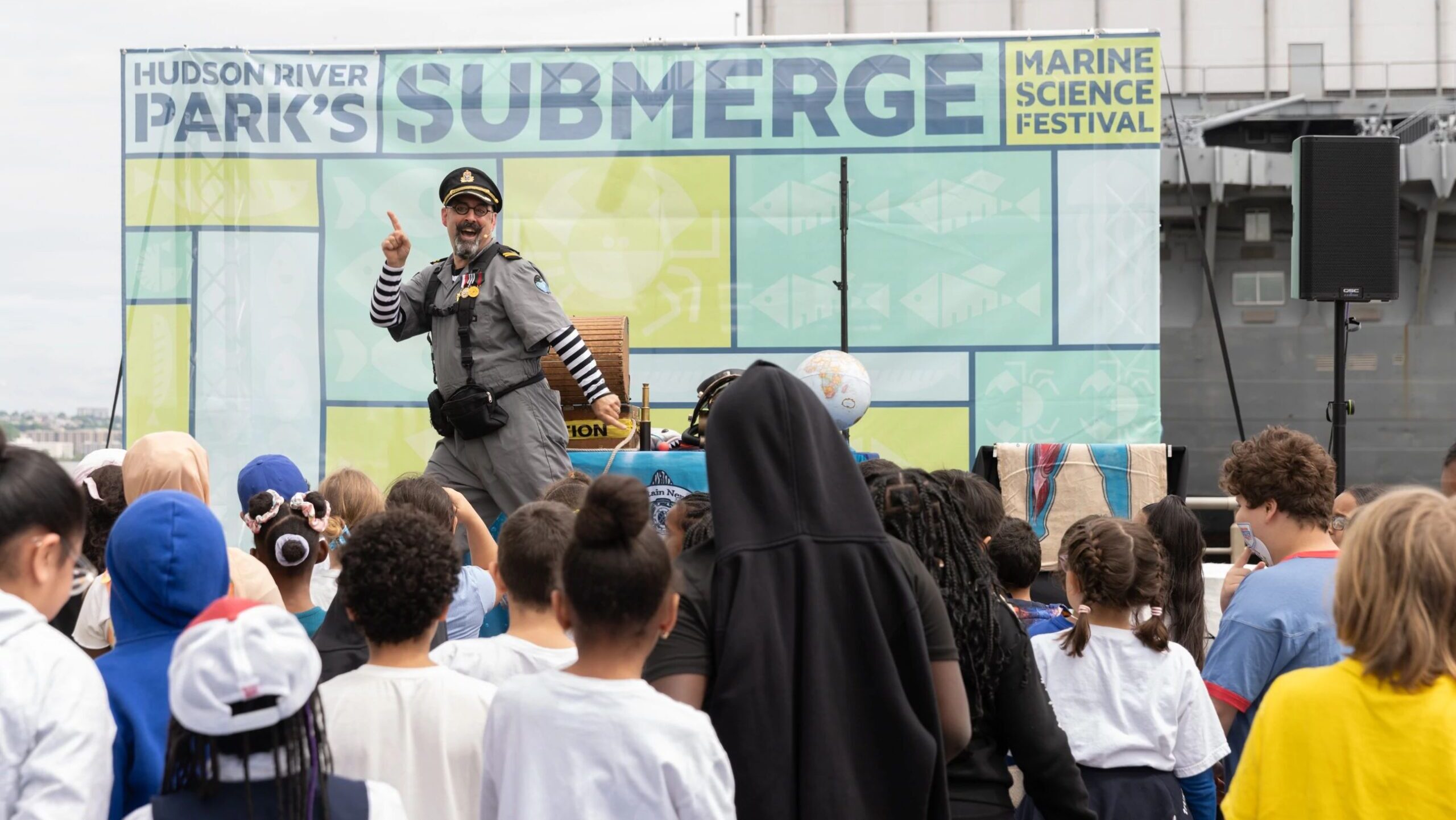 David Engel, dressed in a sea captain's outfit, dances on stage during a performance of Captain Nemo's Adventure Academy at the SUBMERGE Marine Science Festival