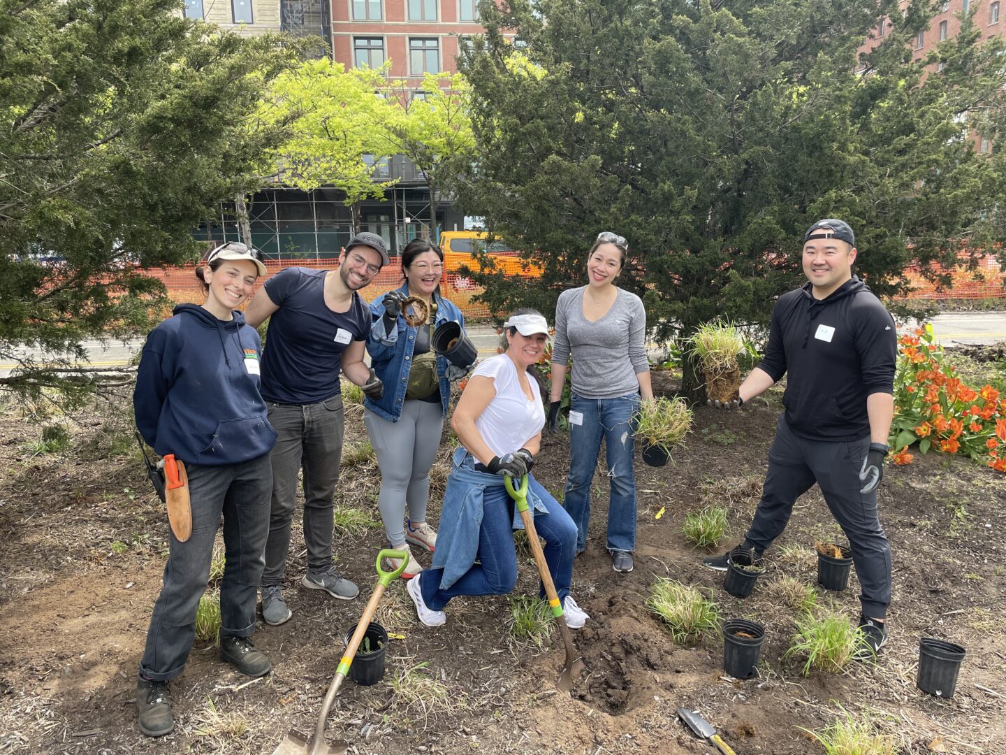 A group of HRPK Green Team volunteers pose for a photo in a garden bed