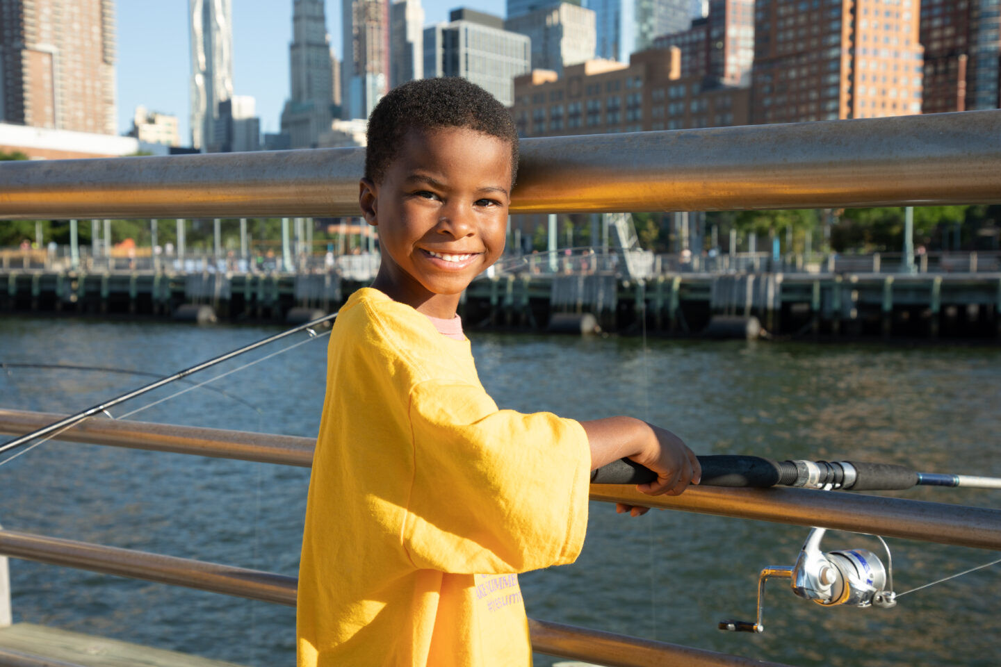 A child smiles after casting a line at Big City Fishing